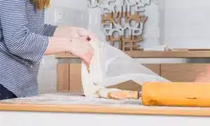 little-girls wipe dough-table with kitchen towel