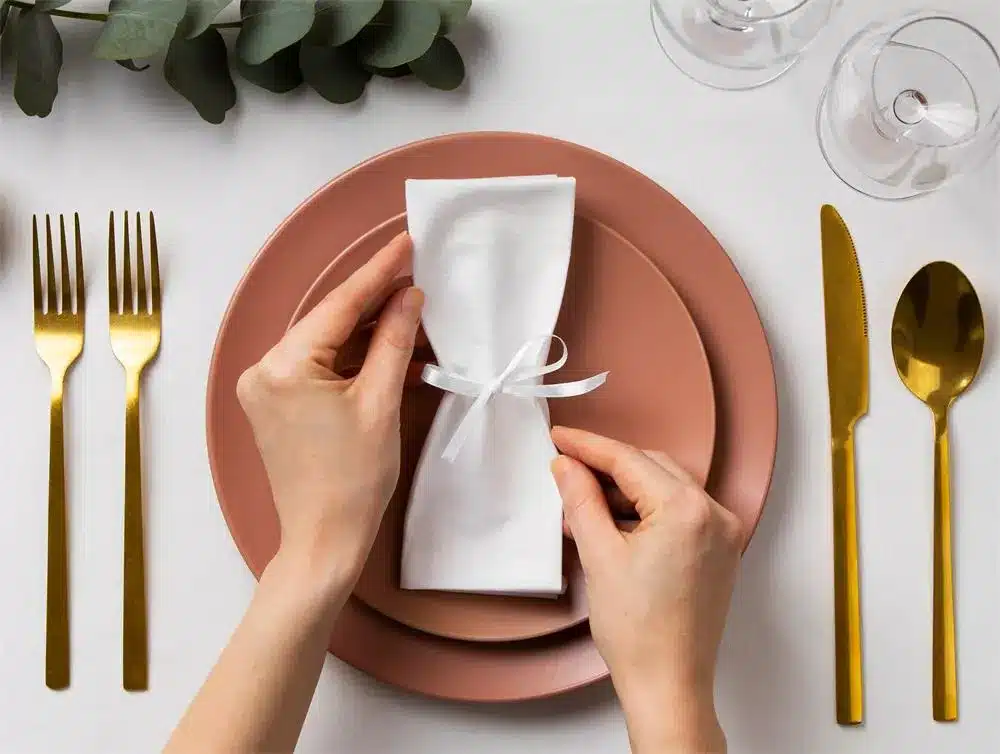 top view wedding planner arranging table with napkin