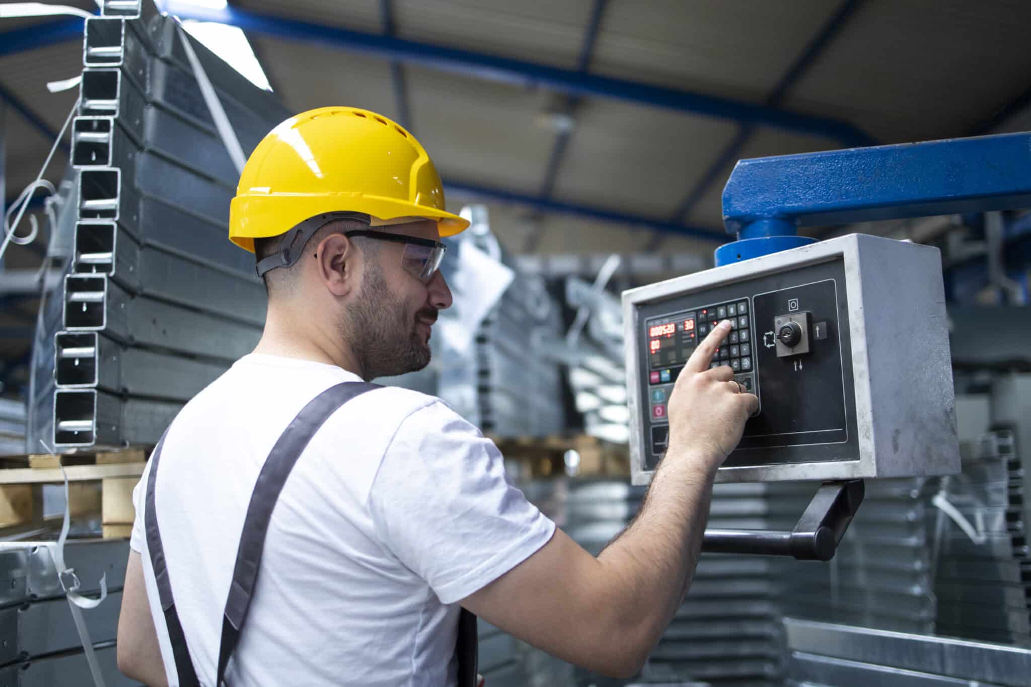 factory worker operating industrial machine setting parameters computer scaled